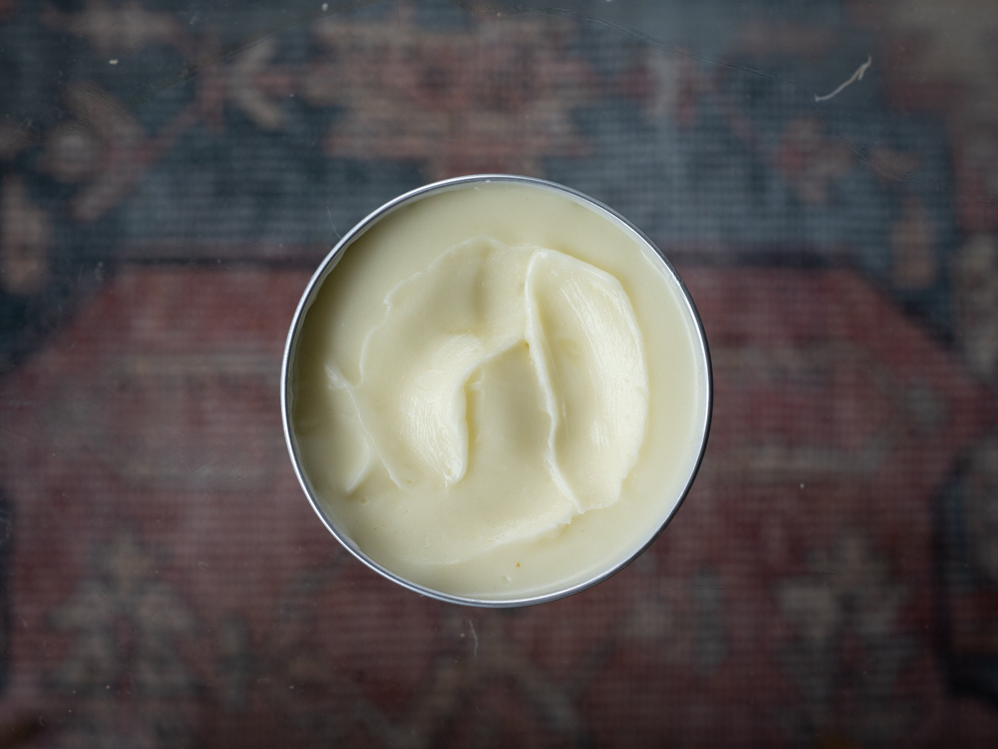 Close-up of Oliba tallow balm with a smooth, creamy texture in natural light